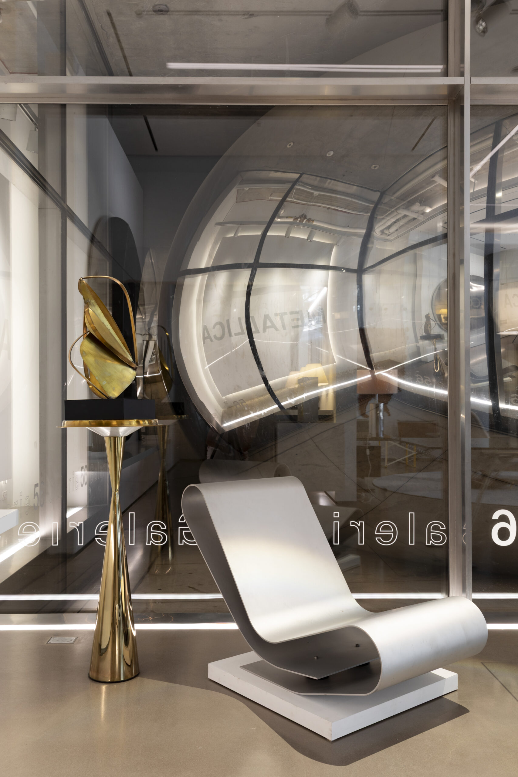 low chair of bent aluminum by maarten van severen with brass sculpture on tom dixon base in Galerie56 with anish kapoor in background